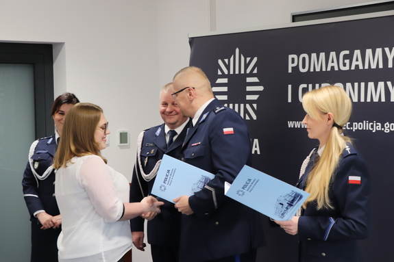 Zdjęcie przedstawia Komendanta Miejskiego Policji w Sosnowcu z Zastępcami wręczających dyplom pracownicy.