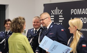 Zdjęcie przedstawia Komendanta Miejskiego Policji w Sosnowcu wraz z Zastępcami wręczających dyplom pracownicy.