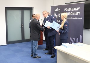 Zdjęcie przedstawia Komendanta Miejskiego Policji w Sosnowcu wraz z Zastępcami wręczających dyplom pracownikowi.