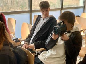 Zdjęcie przedstawia uczniów w sali konferencyjnej sosnowieckiej komendy ze sprzętem specjalistycznym.