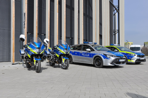 Zdjęcie przedstawia dwa oznakowane radiowozy oraz dwa motocykle służbowe.